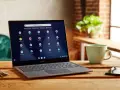 Laptop z systemem Chrome OS Flex, gotowy do pobrania, na drewnianym stole obok kubka i kluczy.