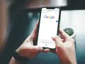 Ręce trzymają telefon z otwartą wyszukiwarką Google. Szukasz informacji, jak usunąć konto Google z telefonu?
