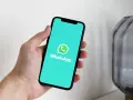 Dłoń trzyma smartfon z logo WhatsApp. Idealne narzędzie do komunikacji, gdy masz internet za granicą.