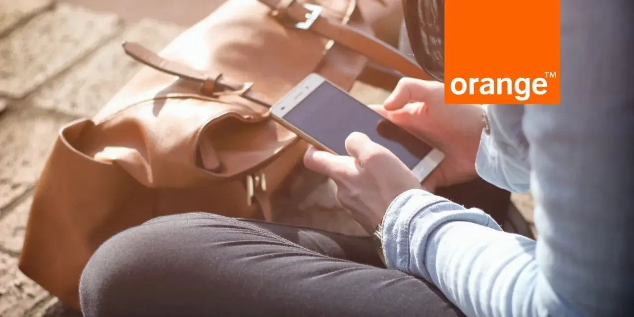 Kobieta z telefonem w dłoni, obok brązowa torba. Idealny dzień na środy z Orange.