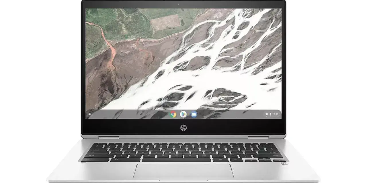 Srebrny laptop HP z systemem **Chromium OS** i klawiaturą. Na ekranie widok z lotu ptaka na krajobraz.