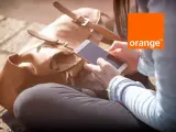 Kobieta z telefonem w dłoni, obok brązowa torba. Idealny dzień na środy z Orange.