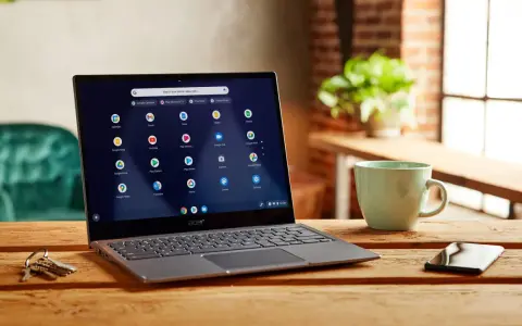 Laptop z systemem Chrome OS Flex, gotowy do pobrania, na drewnianym stole obok kubka i kluczy.