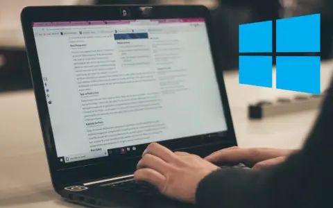 Ręce piszą na klawiaturze laptopa, na ekranie widać artykuł o malowaniu dachu. Obok logo Windows.