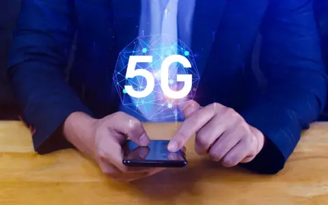 Dłoń na smartfonie, symbol 5G nad nim. Dowiedz się, jak wyłączyć 5G w telefonie, aby kontrolować połączenie.