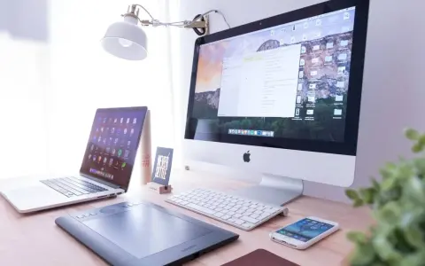 Biurko z iMac, laptopem, tabletem graficznym i telefonem. Na ekranie komputera widać okno programu Adobe Dreamweaver, gotowe do pracy nad stroną.