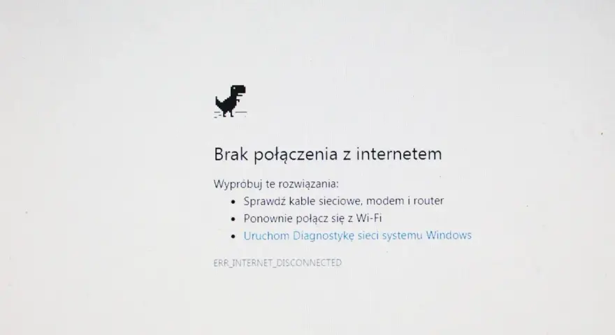 Dinozaur z gry Chrome skacze, bo jest brak internetu. Komunikat "Brak połączenia z internetem" sugeruje sprawdzenie kabli i ponowne połączenie z Wi-Fi.