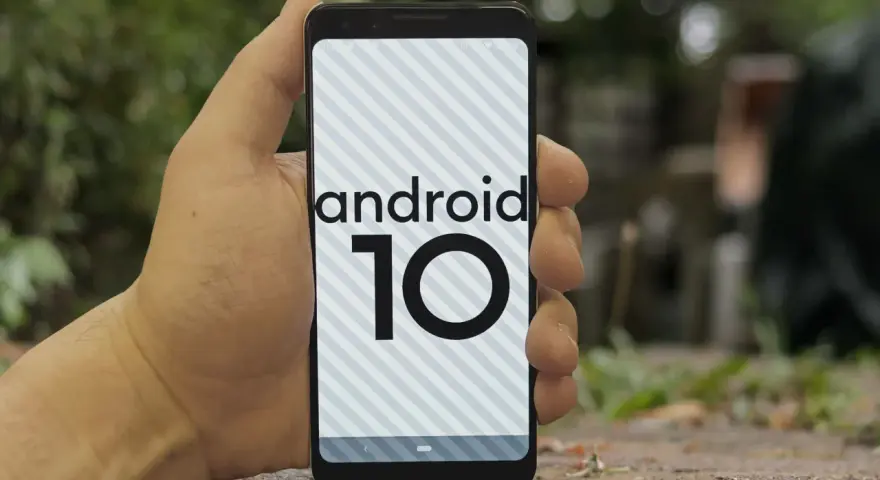 Dłoń trzyma smartfon z logo android 10 na ekranie.